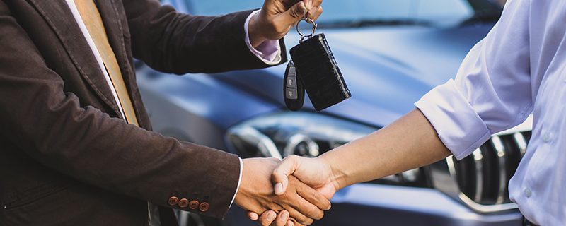 car salesman make a deal and hand over the key
